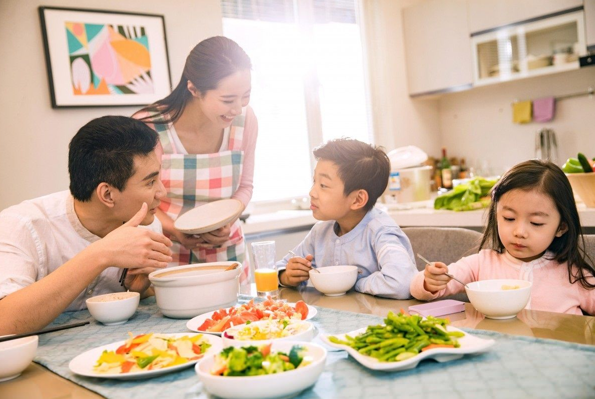 Keluarga sedang menikmati makanan sehat seimbang di meja makan untuk gaya hidup sehat